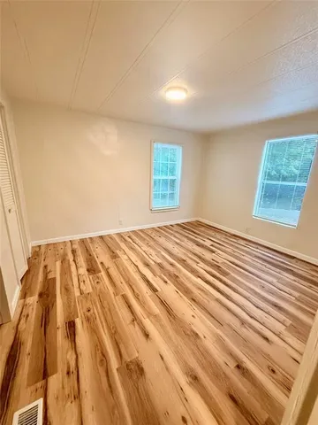 a view of a room with wooden floor and cabinet