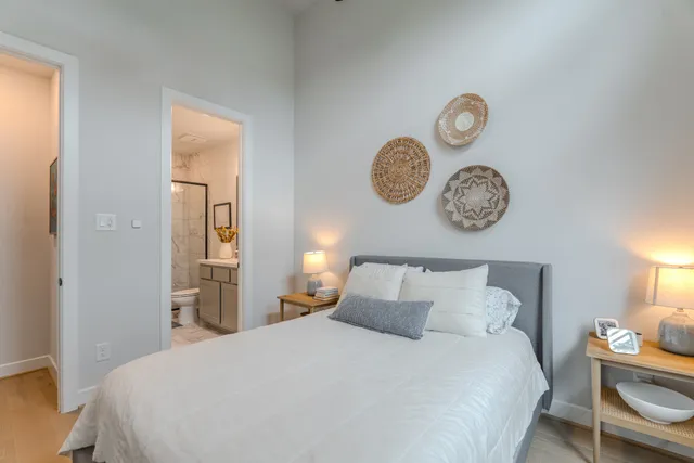 a bedroom with a bed and painting on the wall