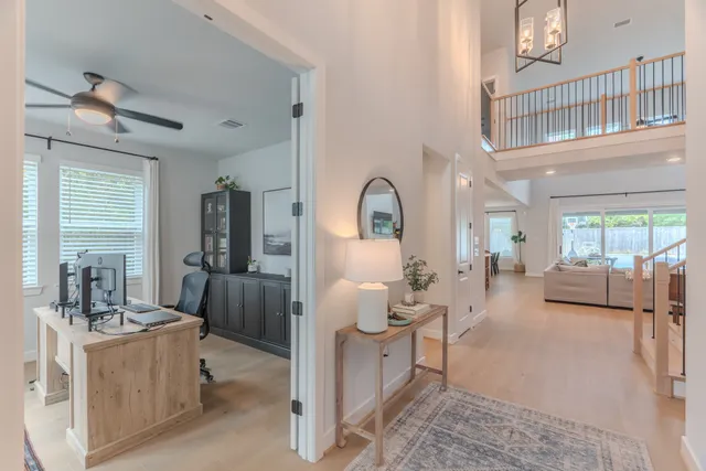 a living room with furniture a rug a ceiling fan and a window