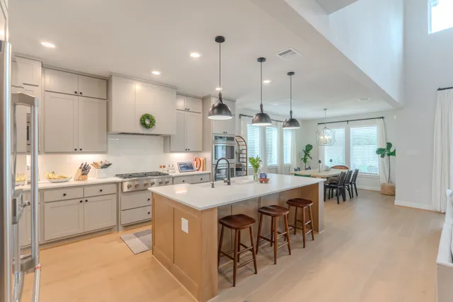 a kitchen with appliances a sink a center island and furniture