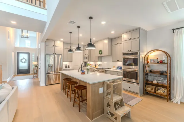 a kitchen with stainless steel appliances kitchen island granite countertop a refrigerator and a stove