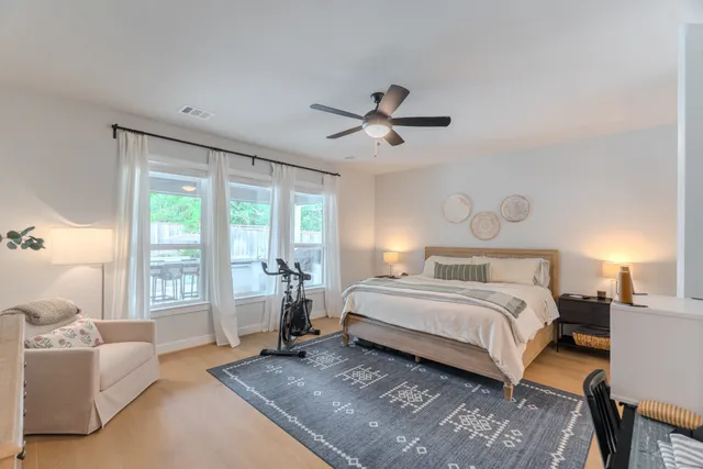 a spacious bedroom with a large bed and a chandelier