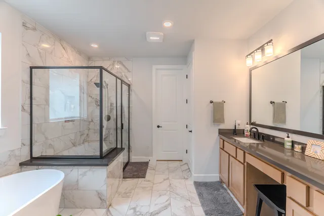 a spacious bathroom with a mirror a bathtub and shower