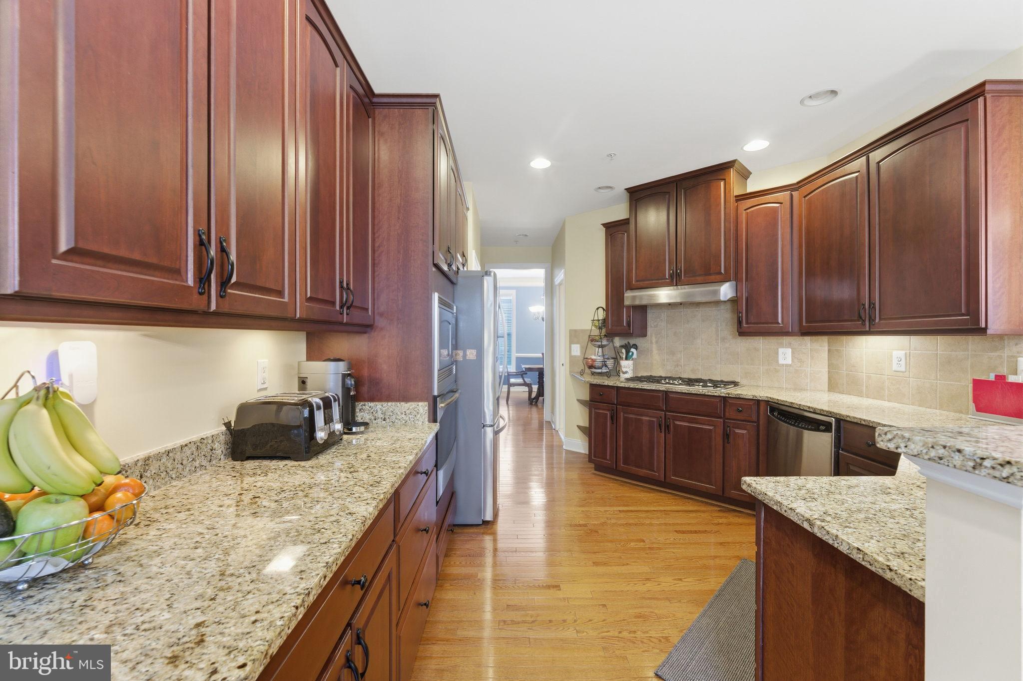 7611 Elmcrest Road Hanover, MD 21076 - Photo 17 of 64 Elegant kitchen with rich wood cabinetry.