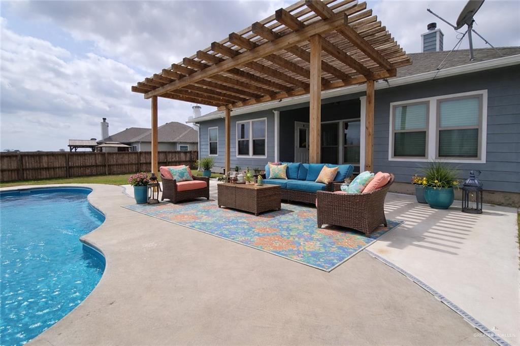 4894 County Road, Unit 2015 Odem, TX 78370 - Photo 8 of 12 Expansive backyard with a curved in-ground pool, concrete patio, and pergola structure