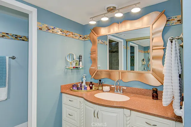 a bathroom with a granite countertop sink and a mirror