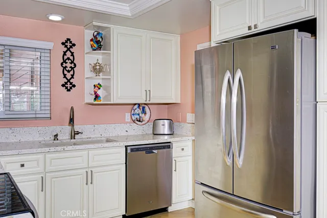a kitchen with stainless steel appliances granite countertop a refrigerator and a sink