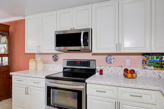 a kitchen with white cabinets and appliances