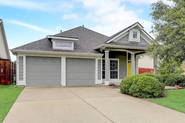 a front view of a house with a garden and garage