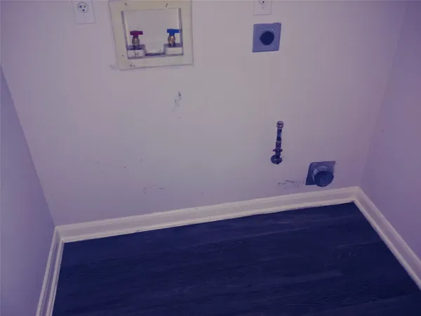 a view of a small space with wooden floor and a window