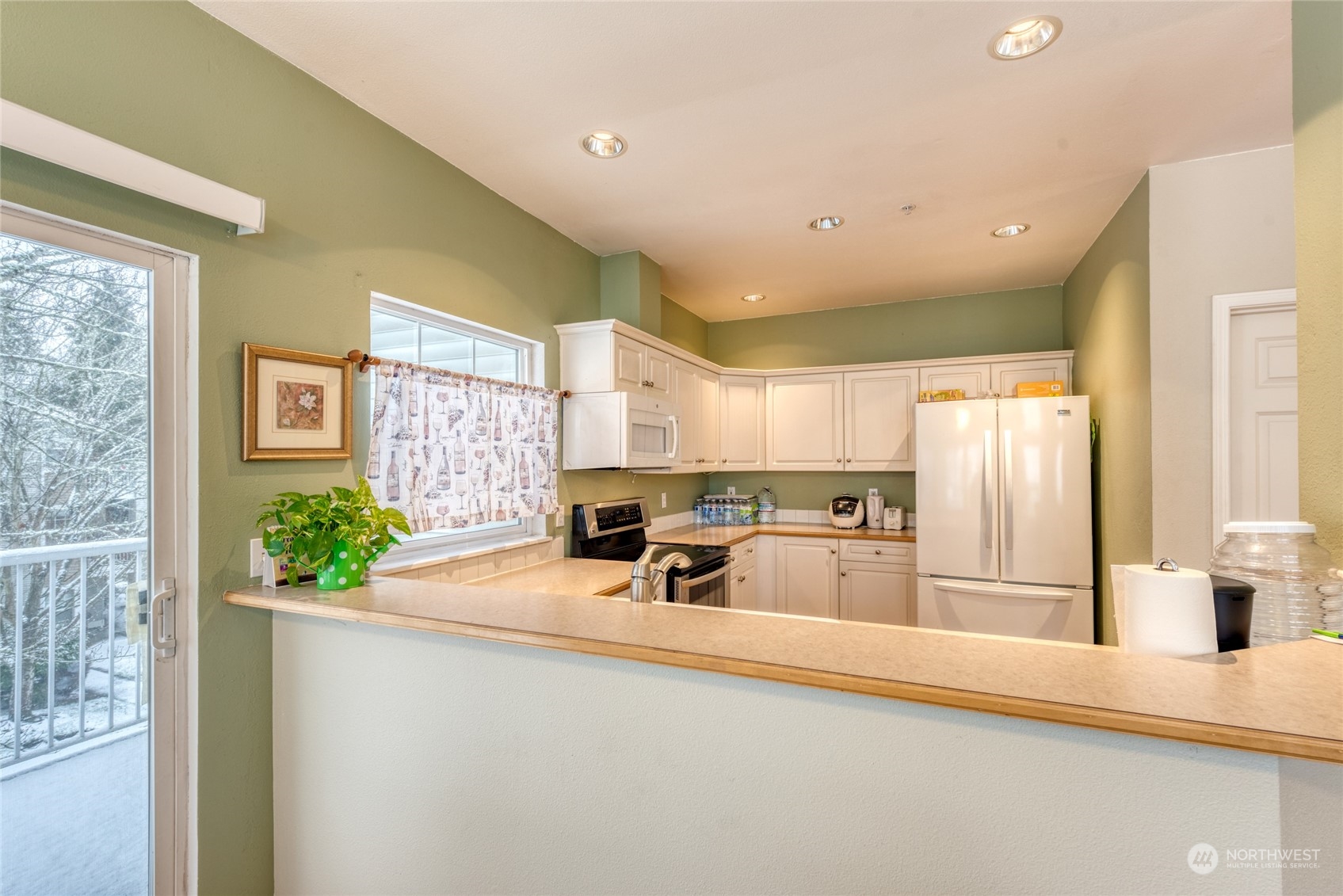 4700 Talbot Road South, Unit 400G Renton, WA 98055 - Photo 8 of 20 a kitchen with kitchen island a counter top space a sink stainless steel appliances and windows
