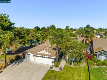 an aerial view of residential houses with outdoor space and trees