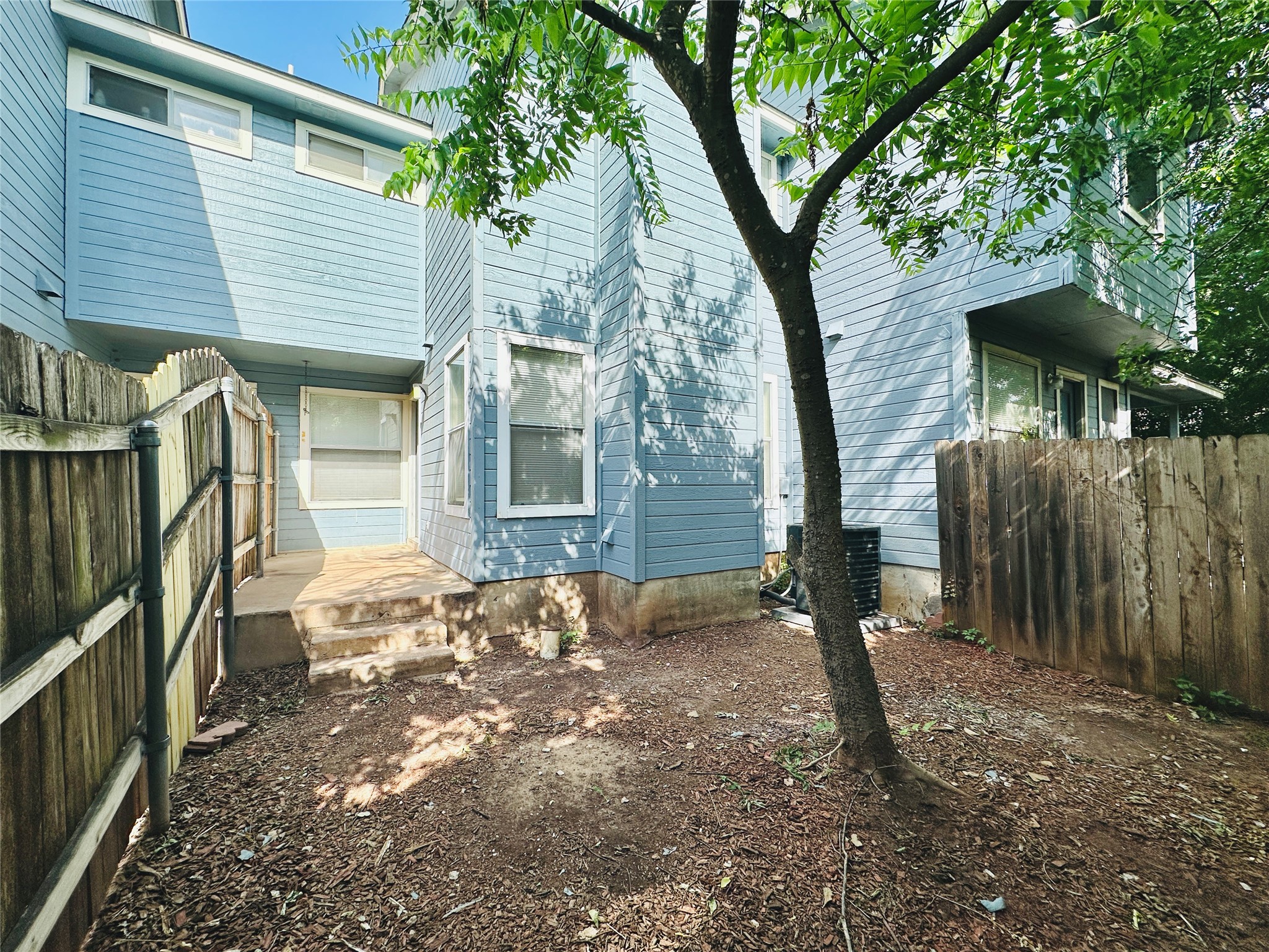 8814 Schick Road, Unit C Austin, TX 78729 - Photo 34 of 35 A private backyard oasis with mature shade trees, offering a tranquil retreat just beyond the home's siding.