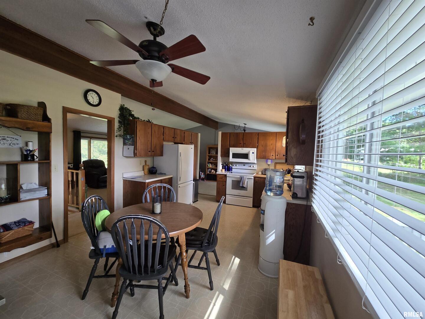 7955 Sugar Grove Road Rushville, IL 62681 - Photo 14 of 28 a dining room with furniture a floor to ceiling window and a ceiling fan