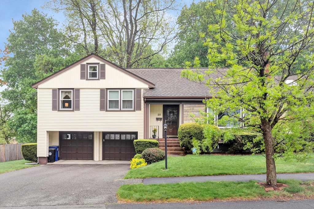 a front view of a house with a garden and yard