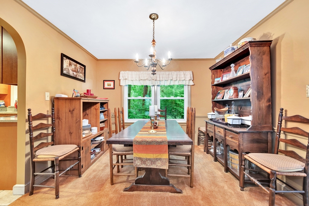 25 Kevin Road Milton, MA 02186 - Photo 26 of 39 a dining room with wooden floor a chandelier a wooden table and chairs