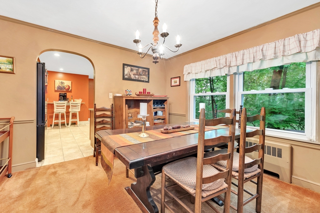 25 Kevin Road Milton, MA 02186 - Photo 27 of 39 a view of a dining room with furniture a chandelier and large windows