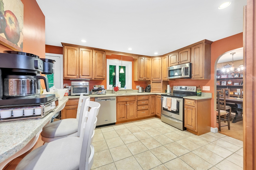 25 Kevin Road Milton, MA 02186 - Photo 32 of 39 a large white kitchen with cabinets a sink a window and stainless steel appliances
