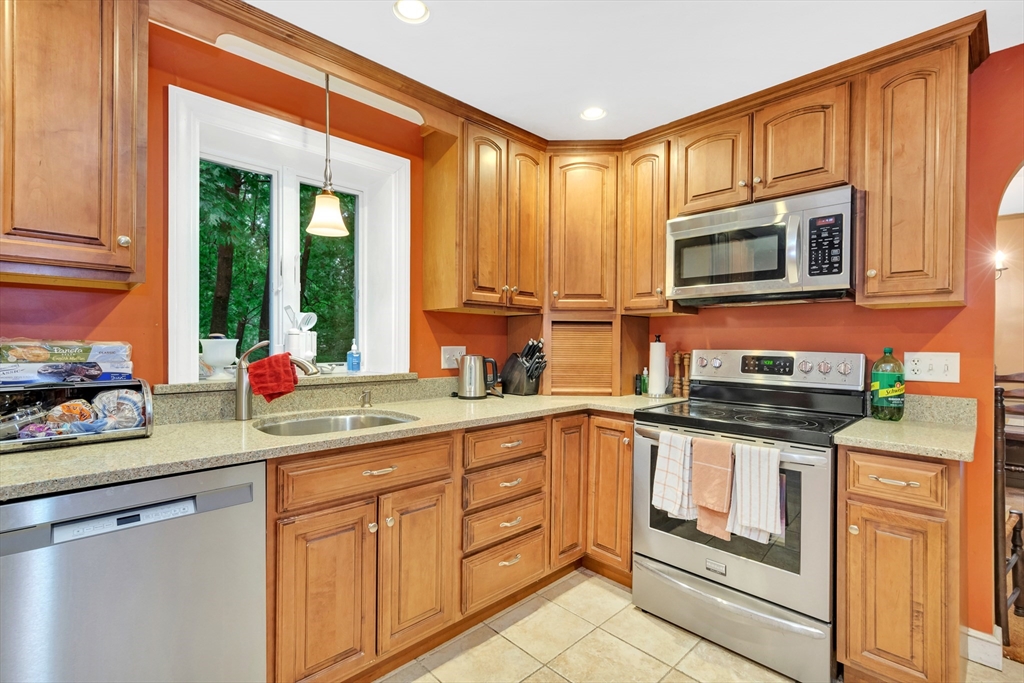 25 Kevin Road Milton, MA 02186 - Photo 33 of 39 a kitchen with stainless steel appliances granite countertop a stove a sink and a microwave