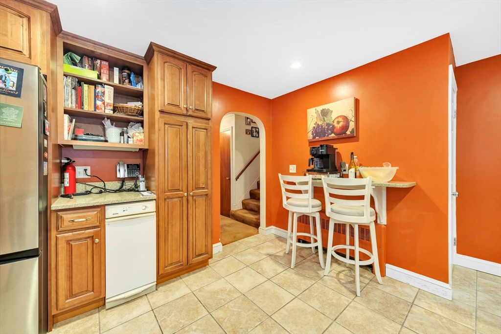 25 Kevin Road Milton, MA 02186 - Photo 35 of 39 a room with stainless steel appliances kitchen island granite countertop furniture and a bookshelf