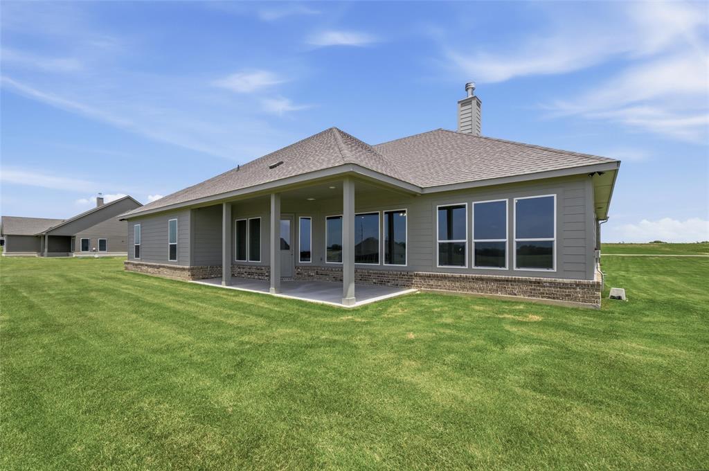 136 Hillview Trail Decatur, TX 76234 - Photo 24 of 26 Expansive rear patio with overhead coverage, multiple large windows, and a brick foundation accent