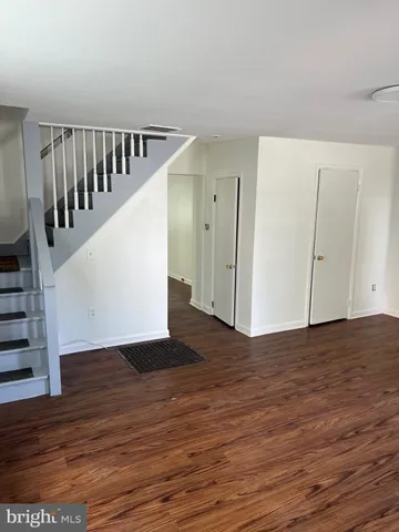 a view of a hallway with wooden floor and stairs