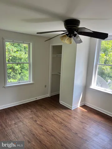 an empty room with wooden floor and a window