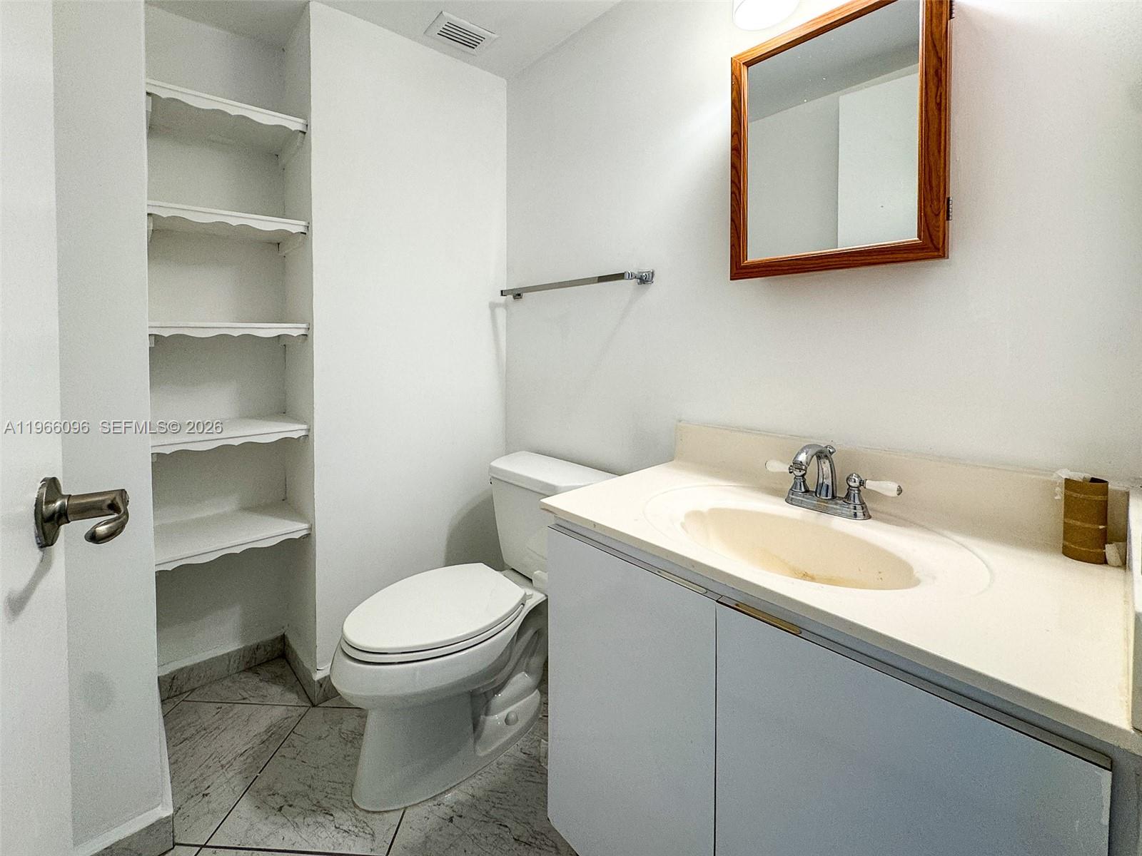 9225 Collins Avenue, Unit 609 Surfside, FL 33154 - Photo 11 of 27 a bathroom with a sink a toilet and a mirror