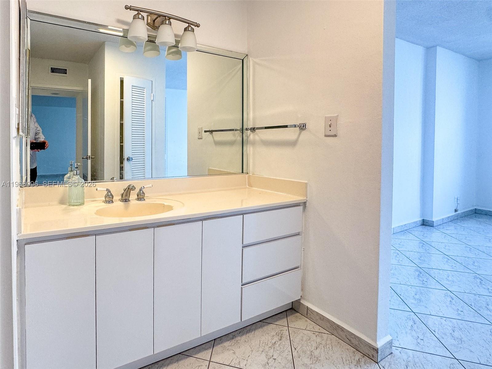 9225 Collins Avenue, Unit 609 Surfside, FL 33154 - Photo 12 of 27 a bathroom with a sink and a mirror