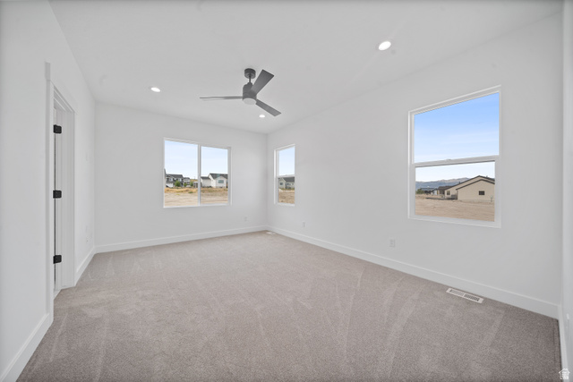 1117 East Shilow Road, Unit 106 Erda, UT 84074 - Photo 8 of 21 Spacious room featuring light gray carpeting, crisp white walls, multiple windows, a contemporary ceiling fan, and recessed lighting