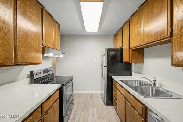 a kitchen that has a sink a refrigerator and cabinets