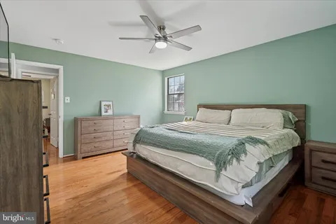 a bedroom with a large bed and a ceiling fan
