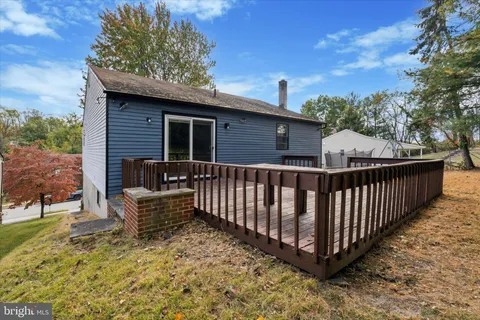 a view of a roof deck with wooden fence and a couple of chairs