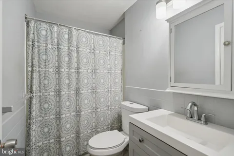a bathroom with a sink a toilet and shower curtain