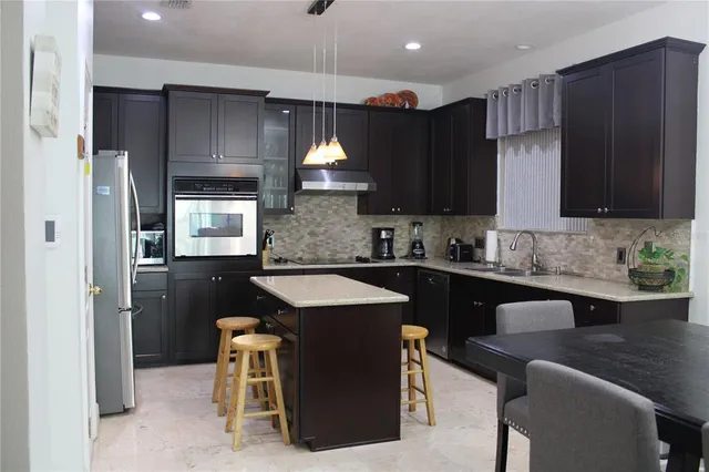 a kitchen with a sink a stove a refrigerator and cabinets