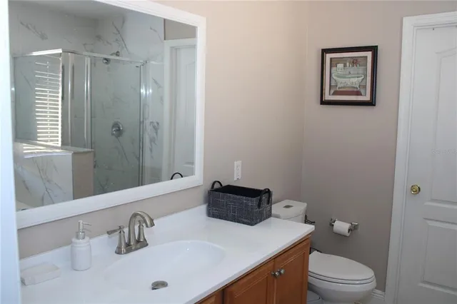 a kitchen with stainless steel appliances granite countertop a dining table chairs refrigerator and sink