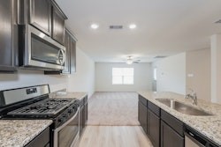 21163 Titan Drive Magnolia, TX 77355 - Photo 10 of 15 a kitchen with granite countertop stainless steel appliances a sink stove top oven and cabinets