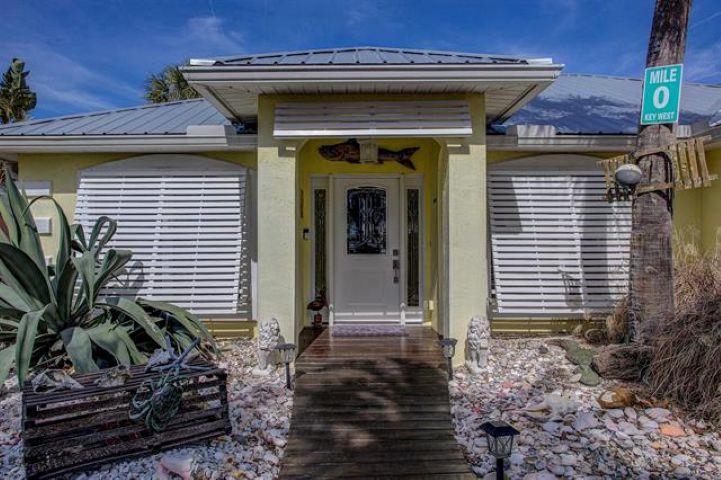 Property entrance featuring a metal roof and stucco siding