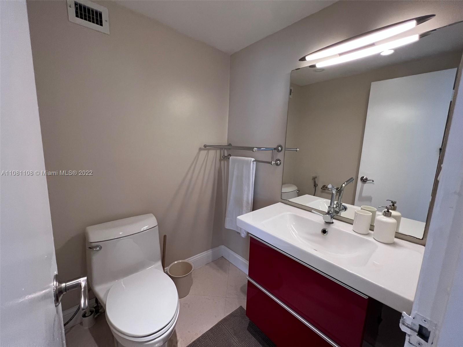 100 Lincoln Road, Unit 1121 Miami Beach, FL 33139 - Photo 11 of 22 a bathroom with a sink mirror vanity and toilet