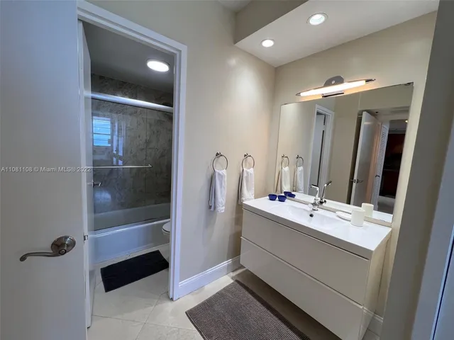 a bathroom with a double vanity sink mirror and shower