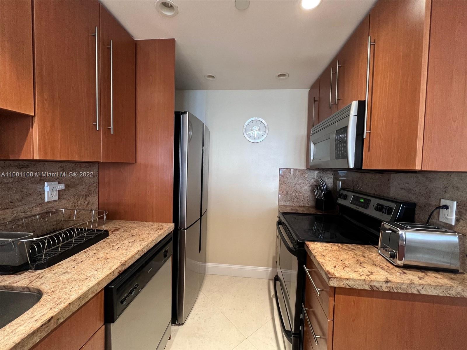 100 Lincoln Road, Unit 1121 Miami Beach, FL 33139 - Photo 8 of 22 a kitchen with granite countertop a stove top oven microwave and cabinets