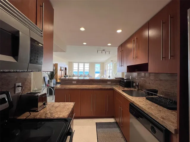 a kitchen with stainless steel appliances granite countertop a sink stove and refrigerator