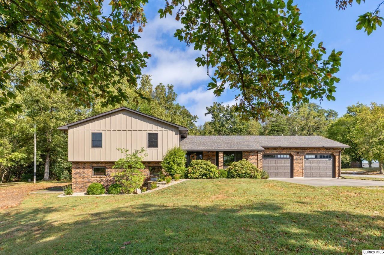 a front view of a house with a yard and trees