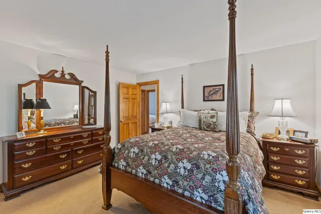 a bedroom with a bed and a flat tv screen on dresser