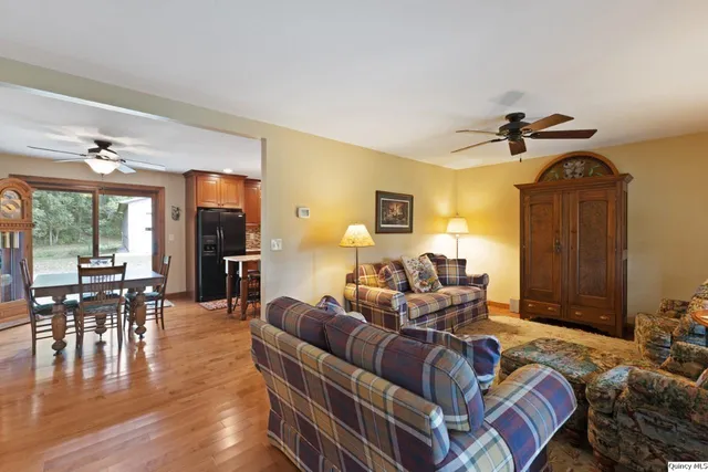 a living room with furniture two window and a dining table