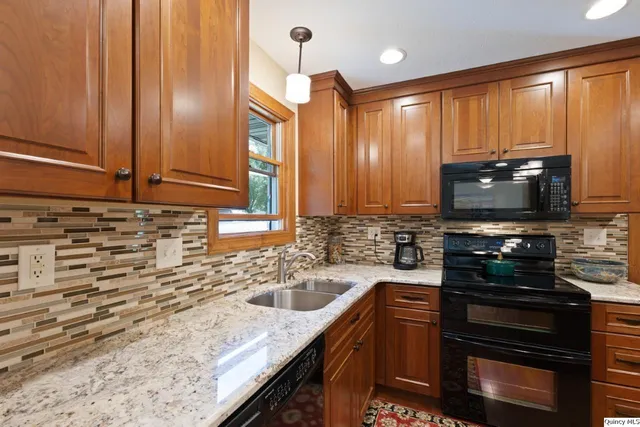 a kitchen with stainless steel appliances granite countertop a sink stove and microwave
