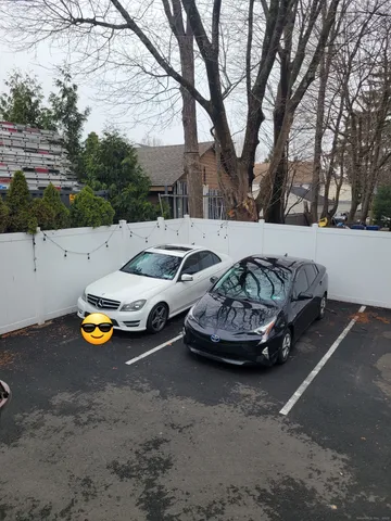 a view of a street with cars parked on the road