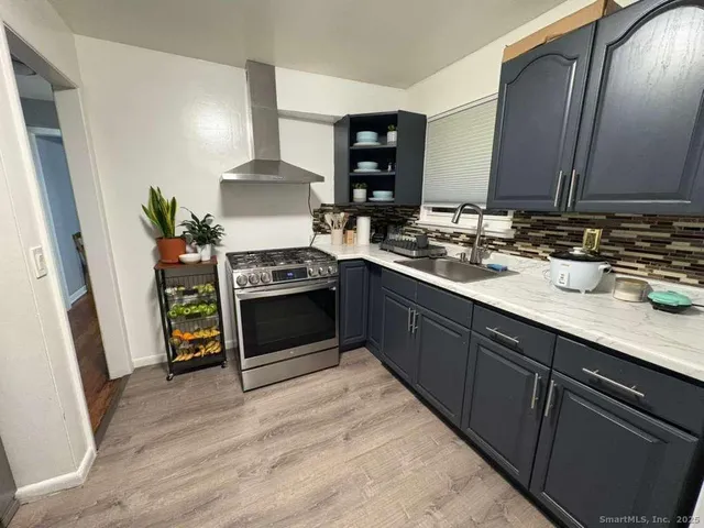 a kitchen with stainless steel appliances granite countertop a sink stove and cabinets