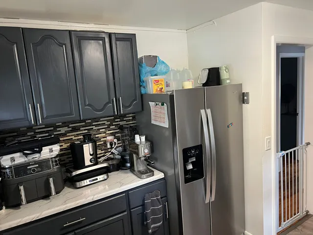 a kitchen with stainless steel appliances granite countertop a refrigerator and a stove