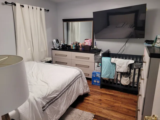 a bedroom with a bed and wooden floor